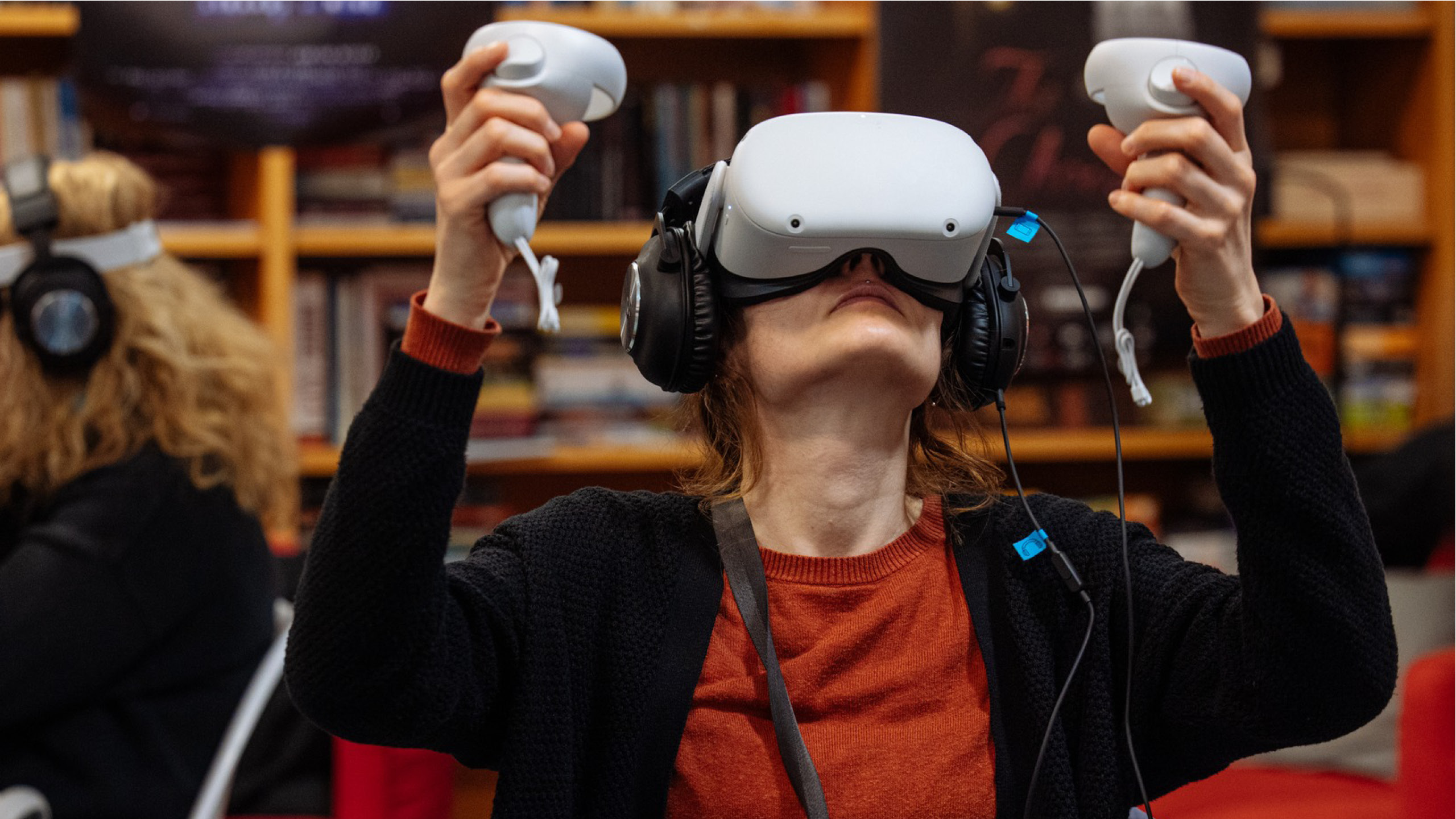 VR_MunicipalLibrary_js_22 Žena sedí a na očích má brýle pro sledování projektu ve virtuální realitě.