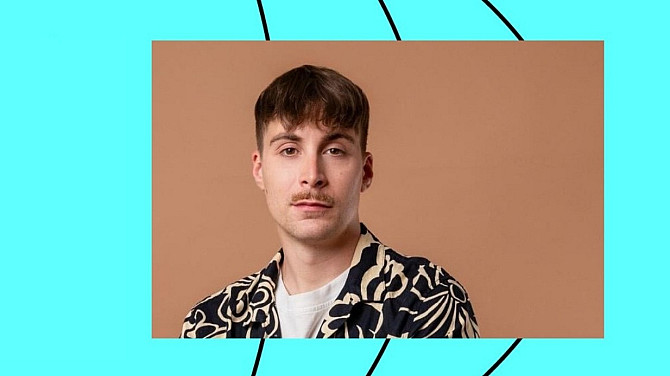 Muž v košili s krátkými vlasy a knírkem.