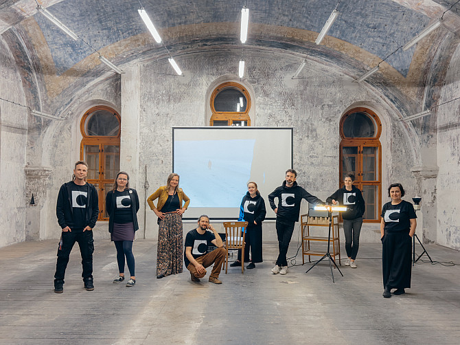 Jeden svět pokračuje v regionech i v dubnu. Promítá nejdiskutovanější i nejkrásnější tituly Skupina několika lidí ve stejných festivalových mikinách a tričkách stojí v prostorné místnosti s klenutým stropem, za nimi je projekční plátno a okna.